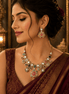 Gold-tone necklace set with green and pink kundan-style stones; matching drop earrings