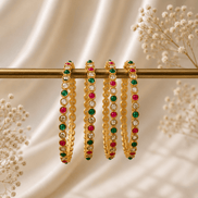 Nayra Royal gold-tone beaded bangles with green and pink stones on a bar