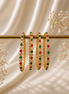 Nayra Royal gold-tone beaded bangles with green and pink stones on a bar