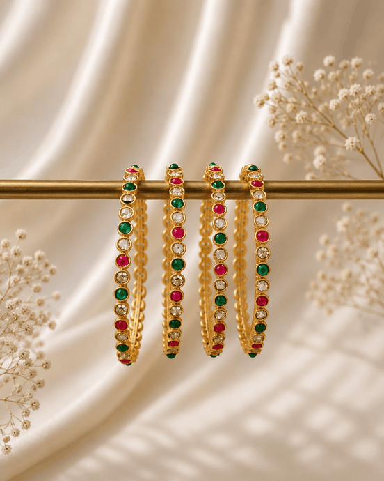 Nayra Royal gold-tone beaded bangles with green and pink stones on a bar
