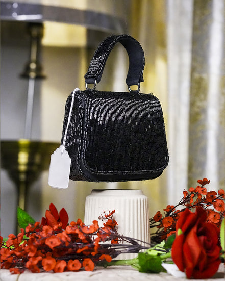 Black crystal mini bag with top handle and small hanging tag