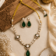 Gold-tone necklace set with green teardrop pendants and pearl bead stations, plus earrings