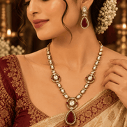 Gold-tone necklace set with red teardrop pendant, pearl beads, and matching drop earrings