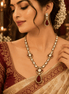 Gold-tone necklace set with red teardrop pendant, pearl beads, and matching drop earrings