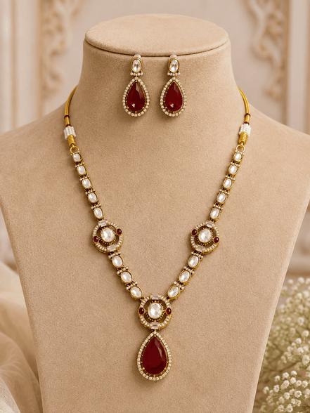 Gold-tone necklace set with red teardrop pendant, pearl bead collar, and matching earrings