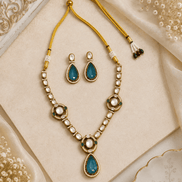 Gold-tone necklace set with green teardrop drop pendant and pearl bead details, with earrings