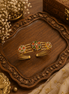 Gold-tone cuff bracelet with multicolor enamel peacock motif and small round accents