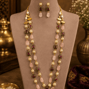 Gold-tone mala necklace set with pink and green stone accents and drop earrings on bust