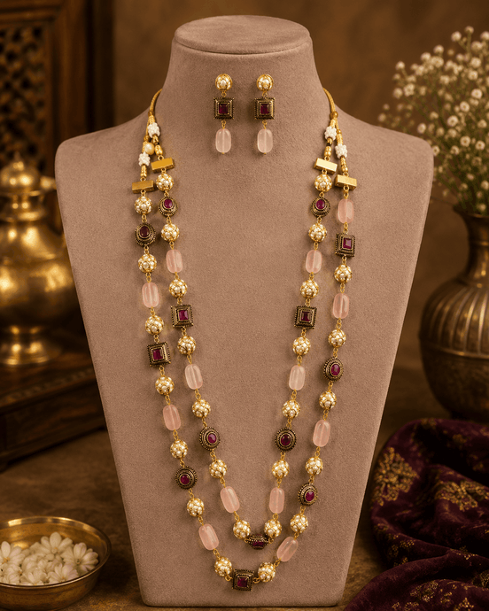 Gold-tone mala necklace set with pink and green stone accents and drop earrings on bust