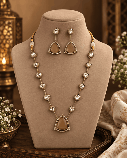 Gold-toned layered necklace with dark red teardrop centerpiece and square bead links