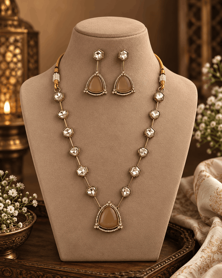 Gold-toned layered necklace with dark red teardrop centerpiece and square bead links