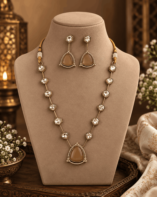Gold-toned layered necklace with dark red teardrop centerpiece and square bead links