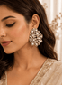 Large pearl and crystal cluster earrings worn by model, gold-tone teardrop detailing