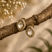 Gold-tone oval stud earrings with clear faceted center stones and sparkle halo frames