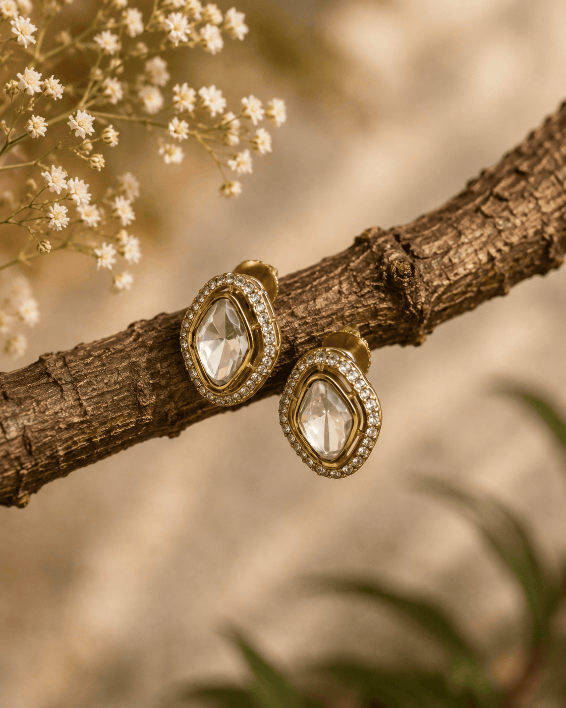 Gold-tone oval stud earrings with clear faceted center stones and sparkle halo frames