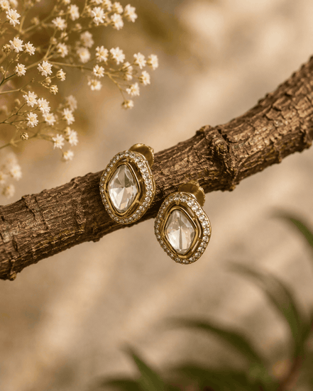 Gold-tone oval stud earrings with clear faceted center stones and sparkle halo frames