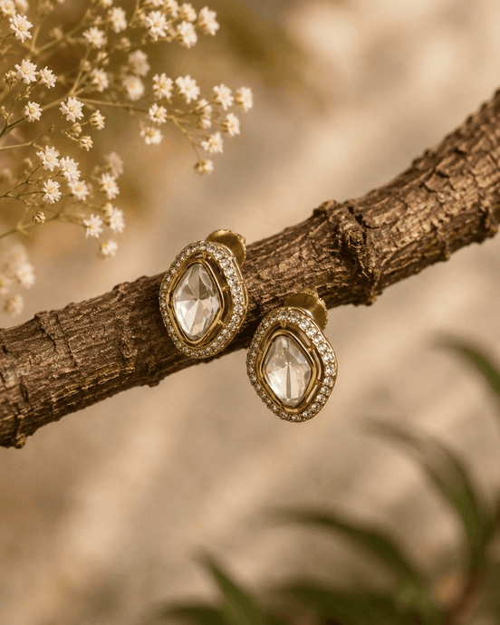 Gold-tone oval stud earrings with clear faceted center stones and sparkle halo frames