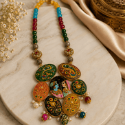 Flat lay of multicolor beaded statement necklace with round hand-painted pendants and small drops