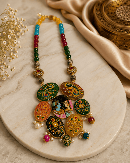 Flat lay of multicolor beaded statement necklace with round hand-painted pendants and small drops