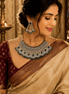 Model wearing bridal kundan necklace set with emerald green stones, pearl fringe, and earrings