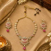 Gold-tone statement necklace with pink teardrop pendant and two matching earrings