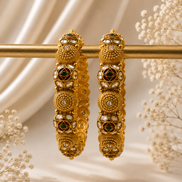 Pair of gold-tone heritage bangles with green stone inlays and circular motifs