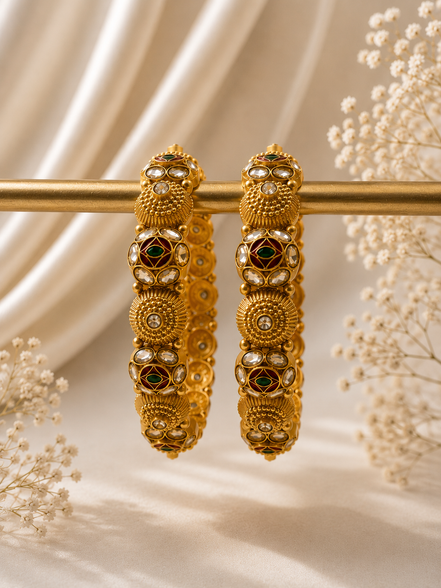Pair of gold-tone heritage bangles with green stone inlays and circular motifs