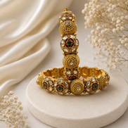 Gold-tone heritage bangle with green stone insets and round kundan-style medallions
