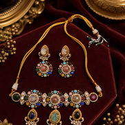 Gold-toned jeweled necklace set with matching drop earrings, maroon, green, and white stones.
