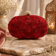 Red beaded clutch with intricate gold-toned detailing; rounded top with gold clasp.