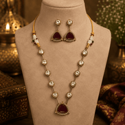 Gold-toned layered necklace with dark red teardrop pendant and long bead drop