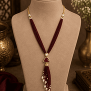 Wine maroon cord tassel necklace with gold oval centerpiece and pearl tassel fringe