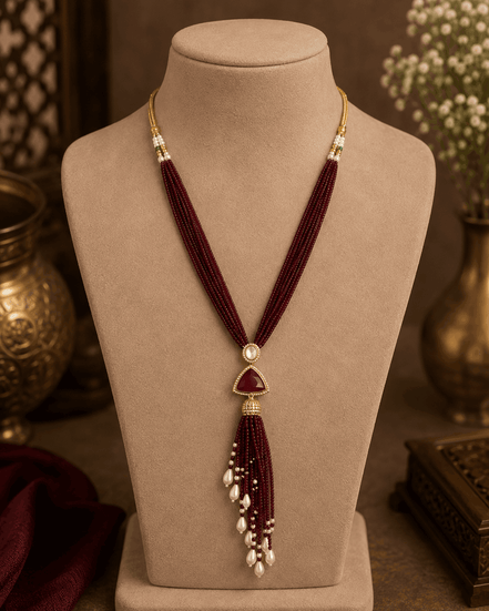 Wine maroon cord tassel necklace with gold oval centerpiece and pearl tassel fringe