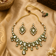 Gold kundan necklace set with green teardrop stones and matching stud earrings