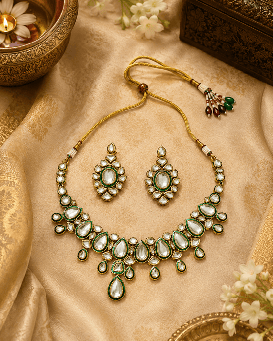 Gold kundan necklace set with green teardrop stones and matching stud earrings