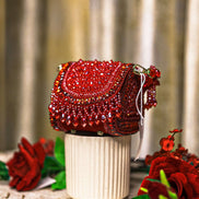 Red crystal mini bag with draped flap, side tassels, and short chain strap