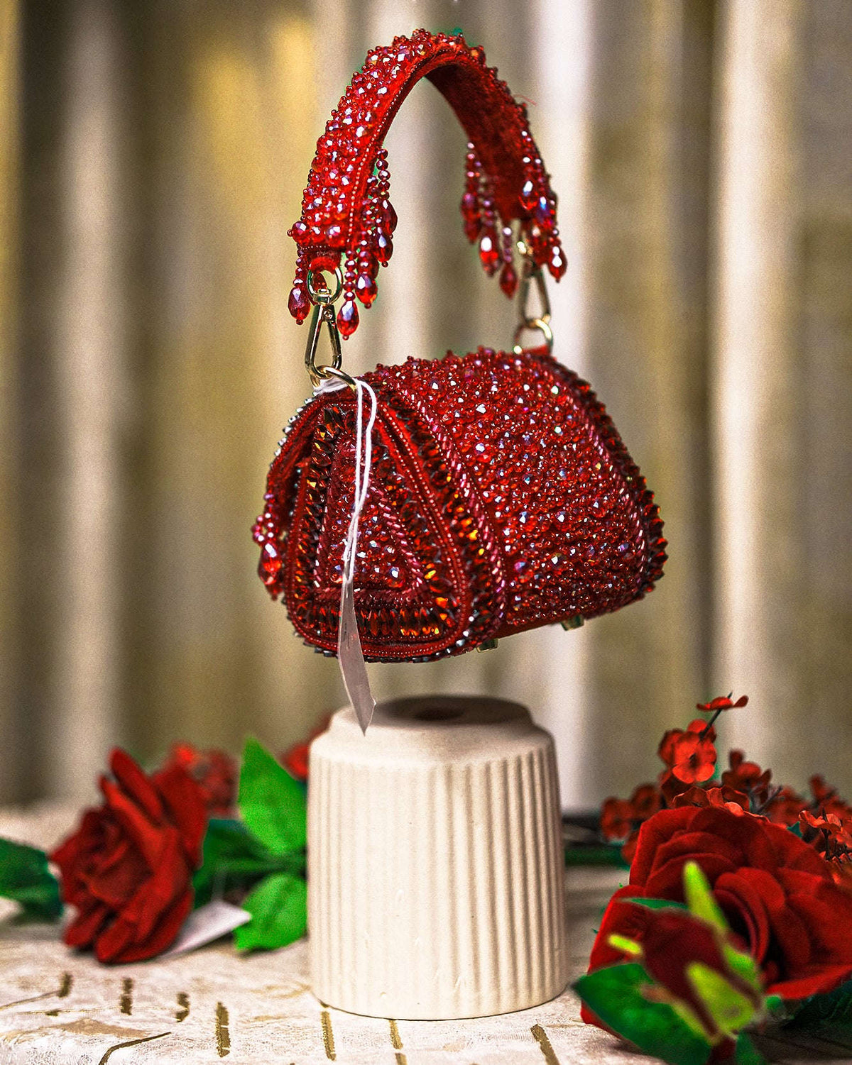 Red crystal mini bag with arched top handle, beaded fringes, and rounded flap