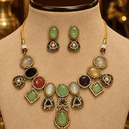 Gold-toned necklace set with green and black round stones, pink and white accents on bust