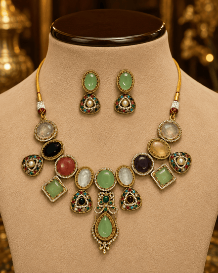 Gold-toned necklace set with green and black round stones, pink and white accents on bust