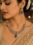 Gold-tone heritage necklace set with blue teardrop pendant and matching dangle earrings