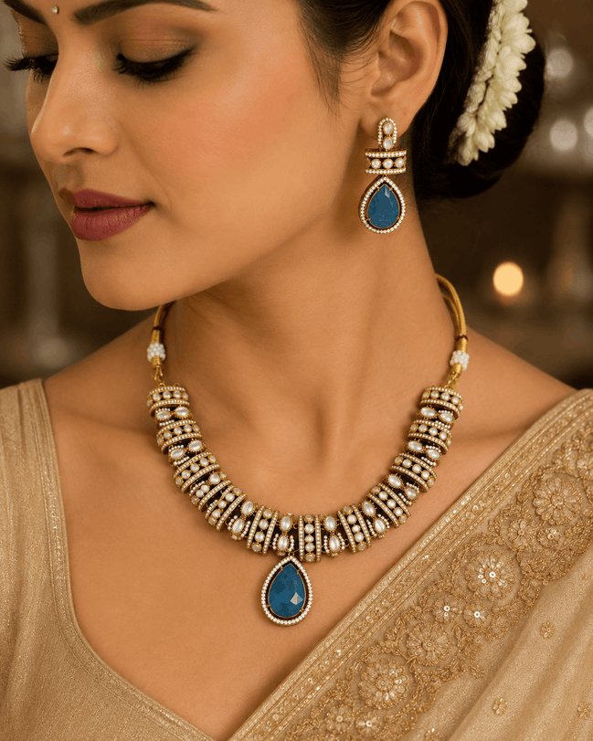 Gold-tone heritage necklace set with blue teardrop pendant and matching dangle earrings