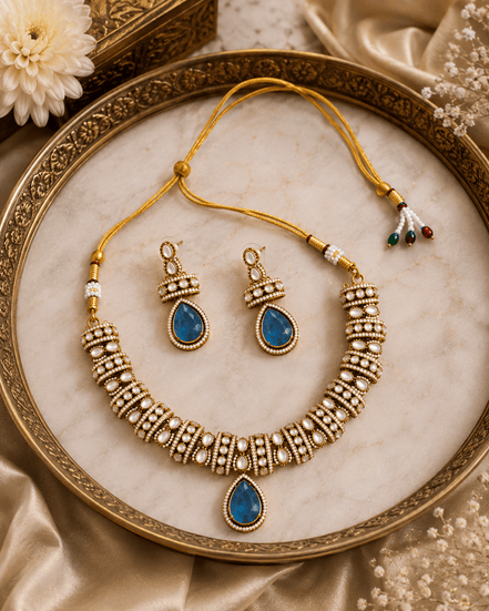 Gold-tone heritage necklace set with blue teardrop pendant and beadwork earrings