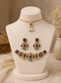 Gold-tone necklace set with purple, black, and teal gemstones; matching drop earrings