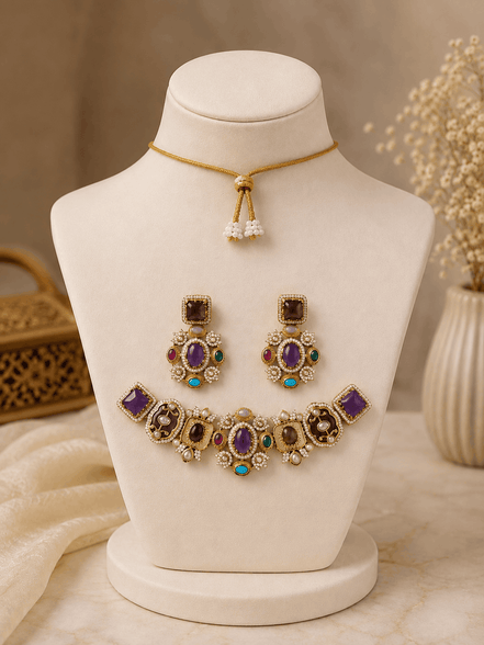 Gold-tone necklace set with purple, black, and teal gemstones; matching drop earrings