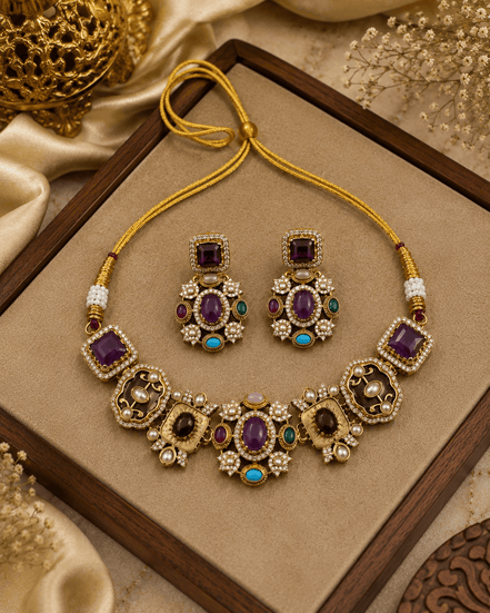 Gold-tone necklace set with purple and teal gemstones on tray; matching drop earrings