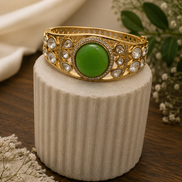 Vintage royal cuff bracelet in gold tone with round green center and crystal accents