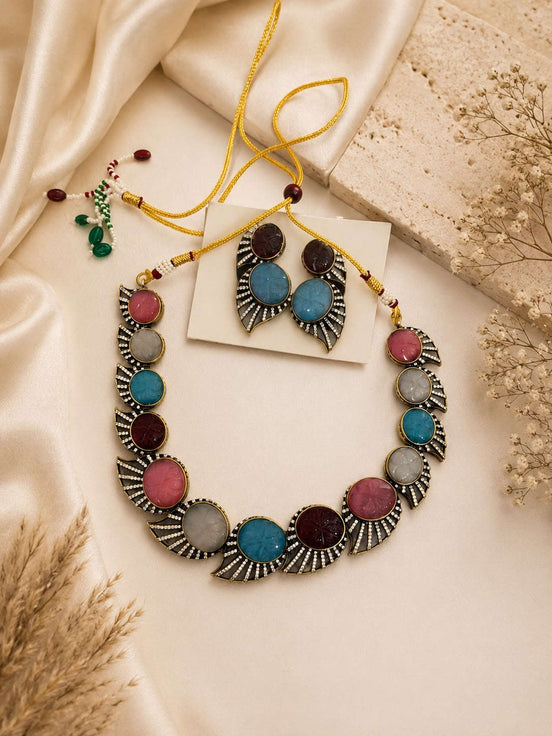 Multicolor stone statement necklace set with circular earrings, gold-tone frame.
