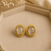 Oval white/clear stone stud earrings with gold-tone ridged bezel