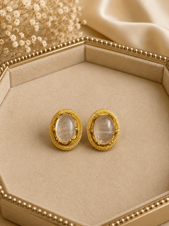 Oval white/clear stone stud earrings with gold-tone ridged bezel