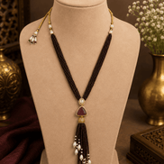 Dark purple cord tassel necklace with gold ring top and teardrop purple centerpiece